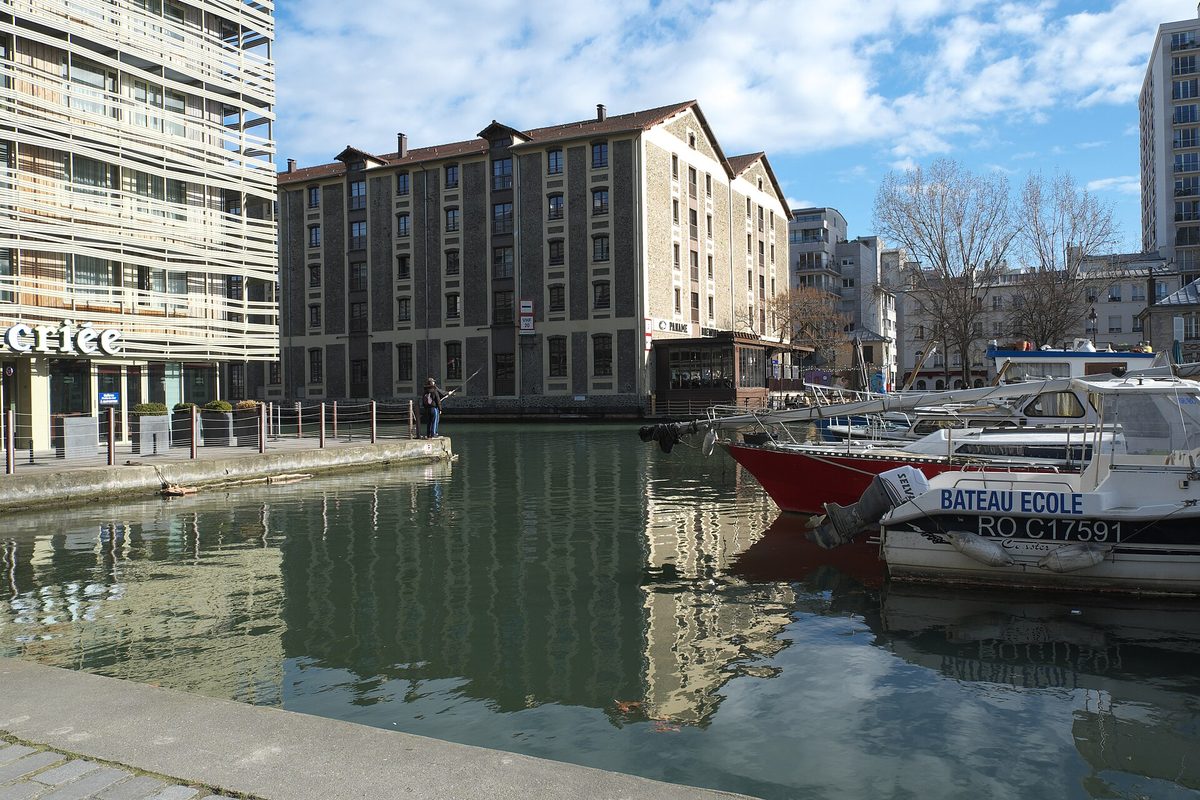 Le bassin de la Villette et ses bateaux amarrés, avec à gauche l'enseigne de La Criée sur le quai de la Seine