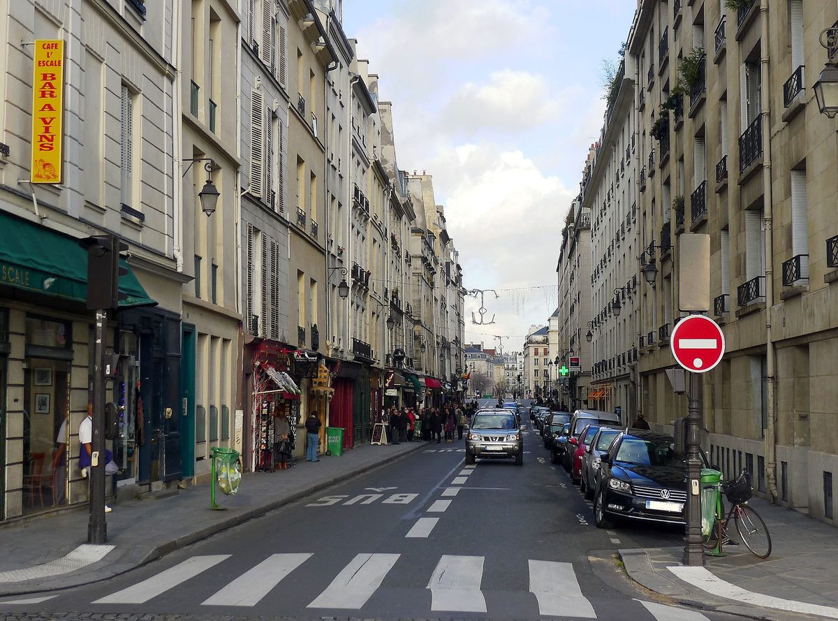 La rue des Deux-Ponts, avec l'enseigne jaune « Café L'Escale, bar à vins » à gauche