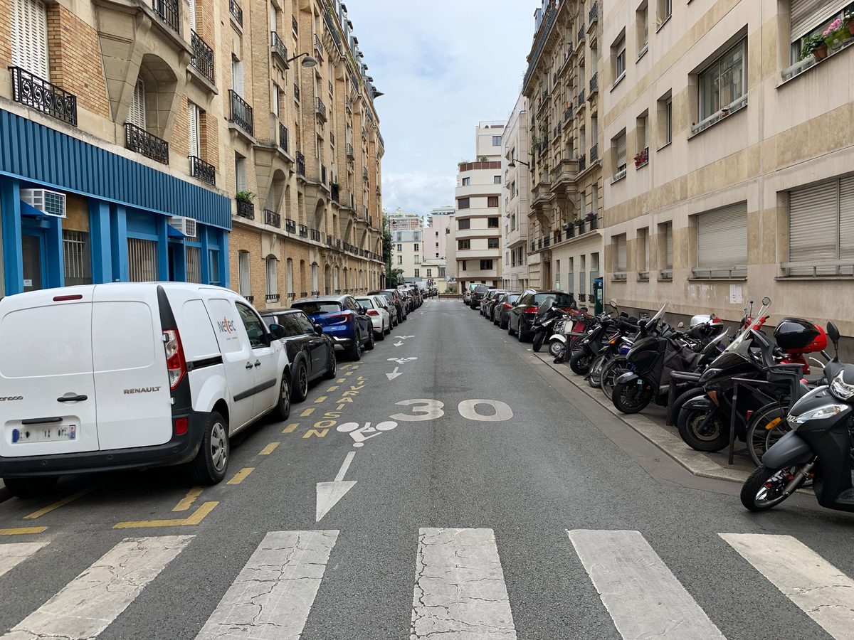 La rue Gerbier, dans le 11e arrondissement de Paris, avec des voitures et des deux-roues garés de part et d'autre