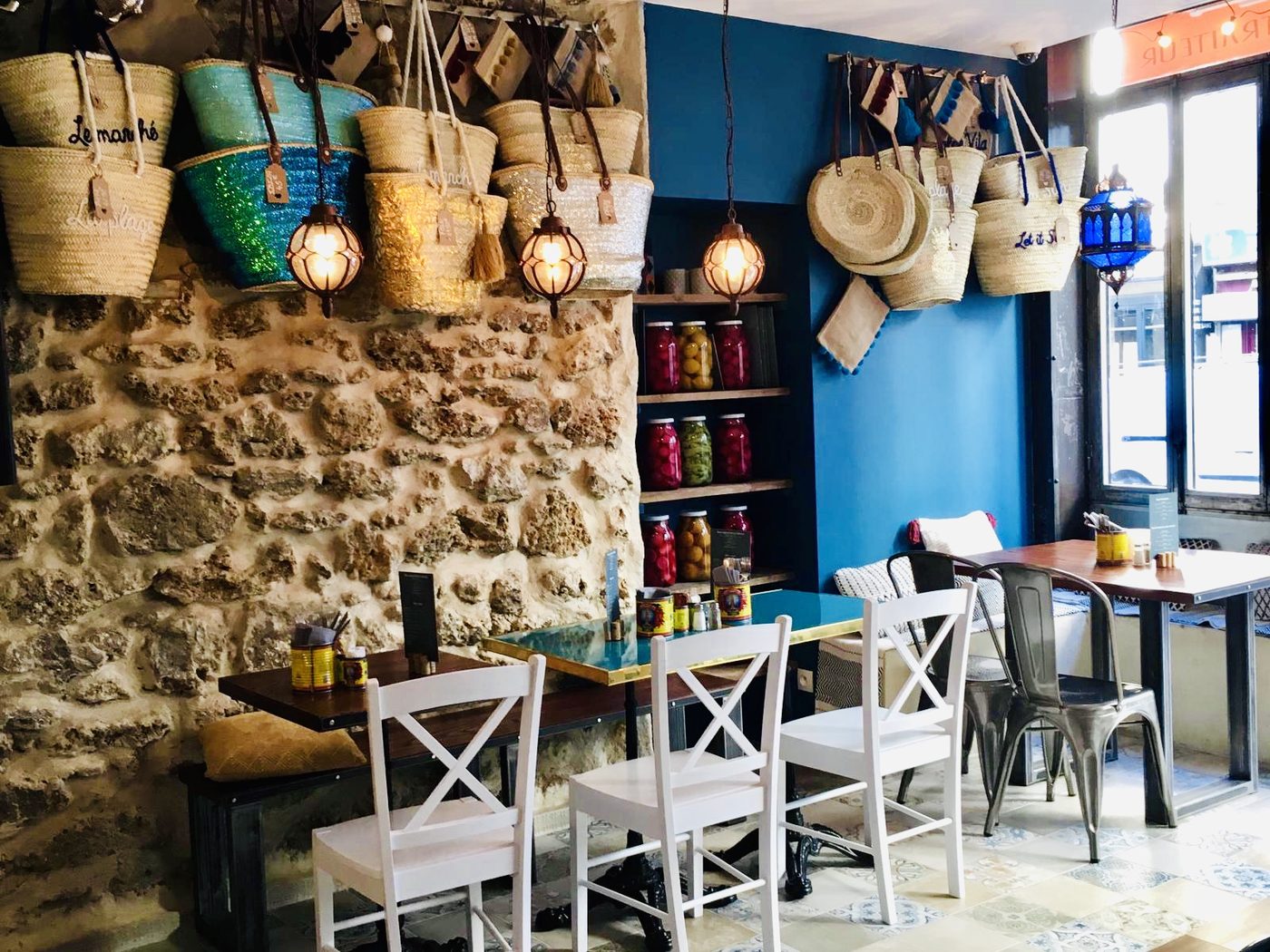Une salle de L'Artisan Libanais, avec son mur de pierre, ses paniers de paille et ses bocaux de pickles