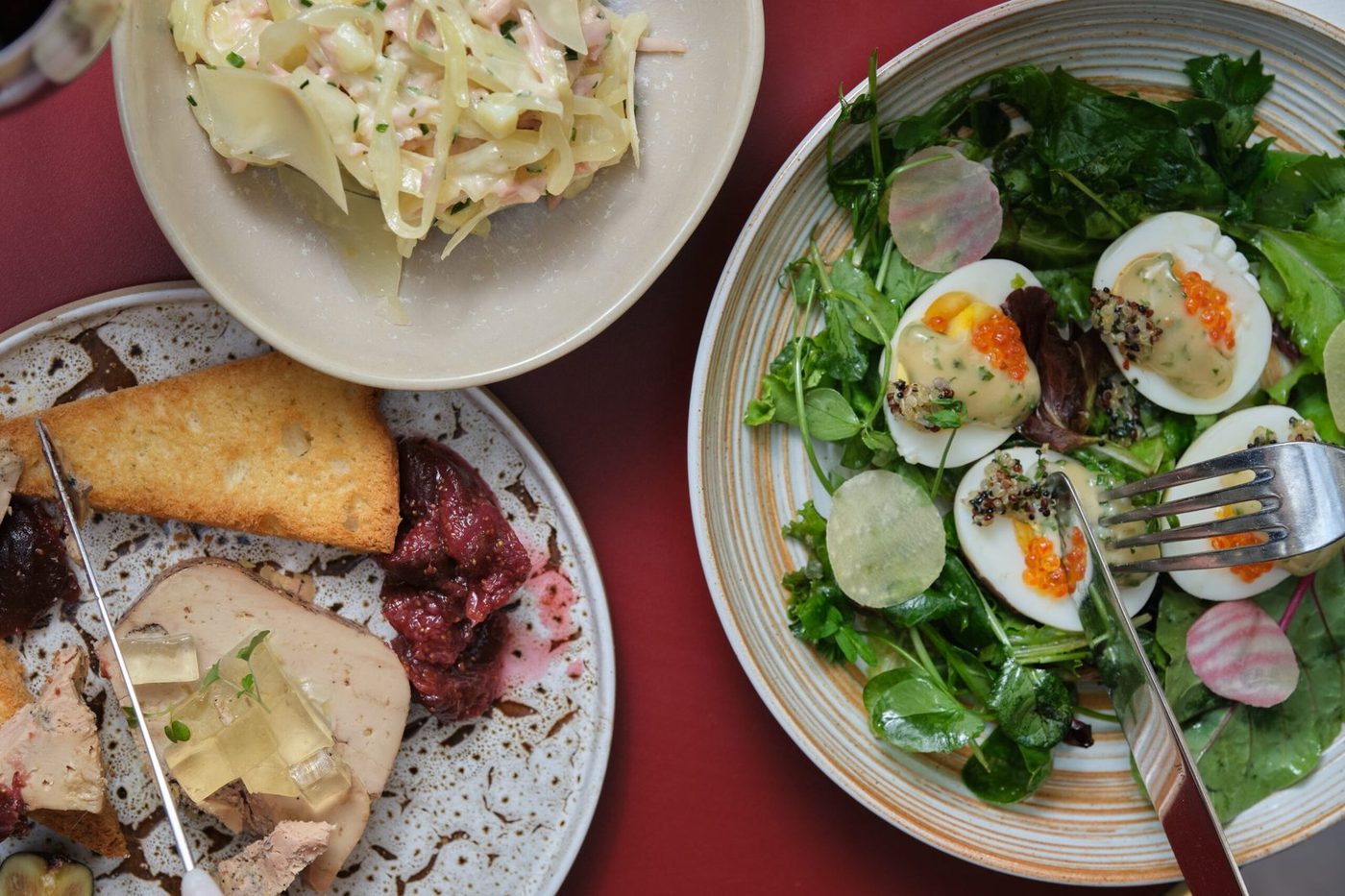 Trois entrées d'Astair sur fond rouge : foie gras et brioche, œufs mayonnaise aux œufs de truite, chou blanc