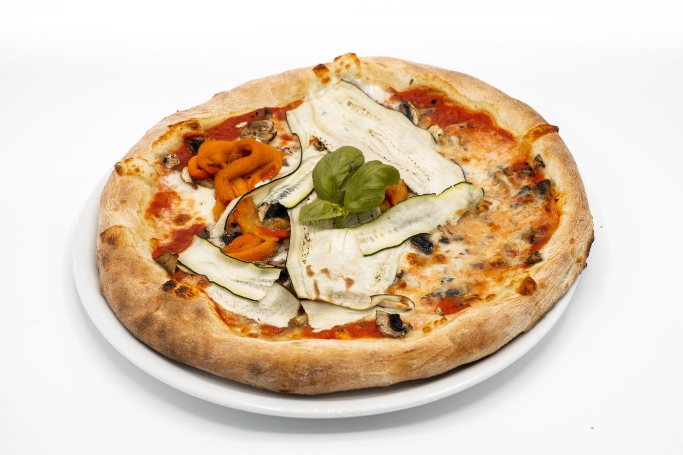 Une pizza aux légumes de Bella Vita, courgette, aubergine, poivrons et champignons, avec un bouquet de basilic