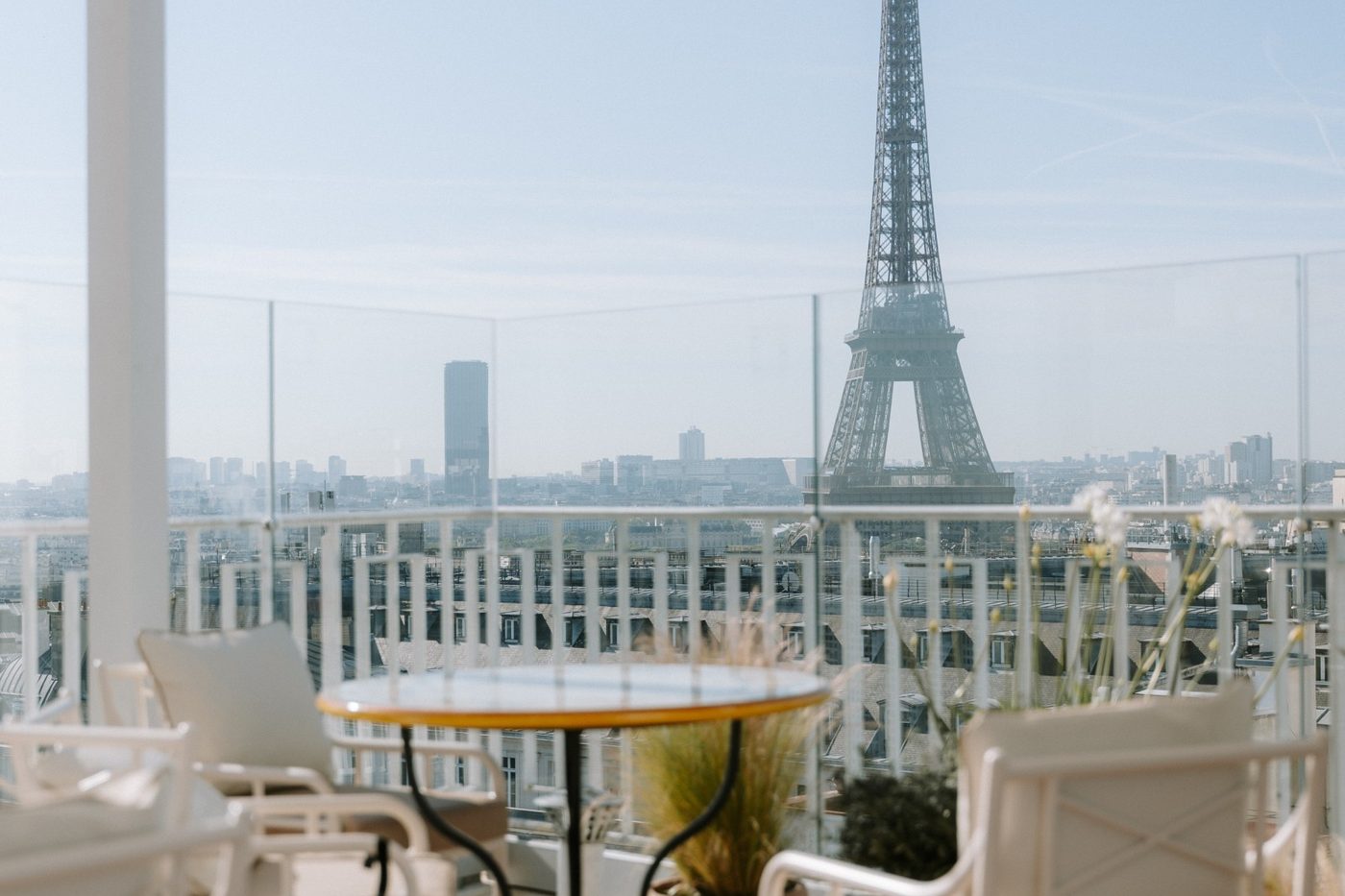 La terrasse de Bigoudi, fauteuils blancs et table ronde, face à la tour Eiffel