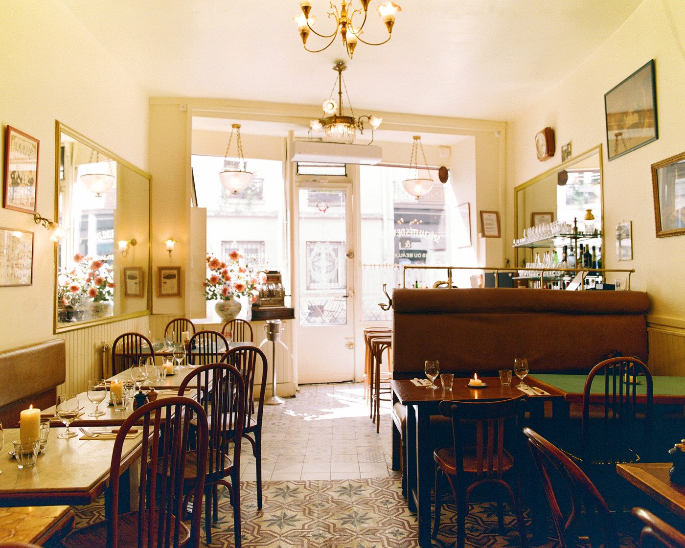 La salle du Bistrot des Tournelles : chaises bistrot, carrelage ancien, miroirs et lustre