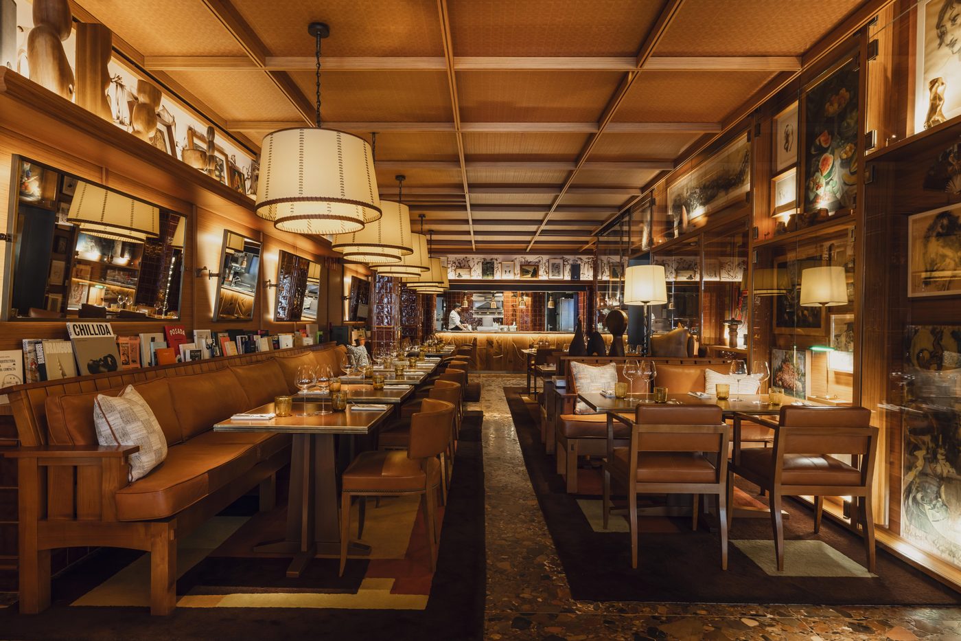 La salle du restaurant Brach Madrid : banquette de cuir fauve, boiseries et suspensions à abat-jour