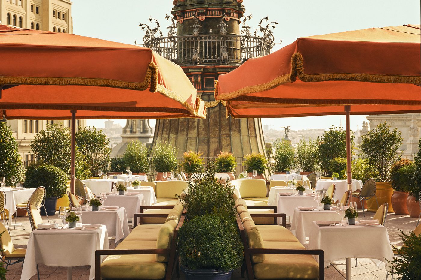 La terrasse de Dani Brasserie sur le toit du Four Seasons, parasols orange à franges et tables dressées