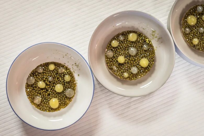 Trois assiettes creuses de Flocons de Sel garnies de petits pois et de perles crémeuses, sur nappe blanche