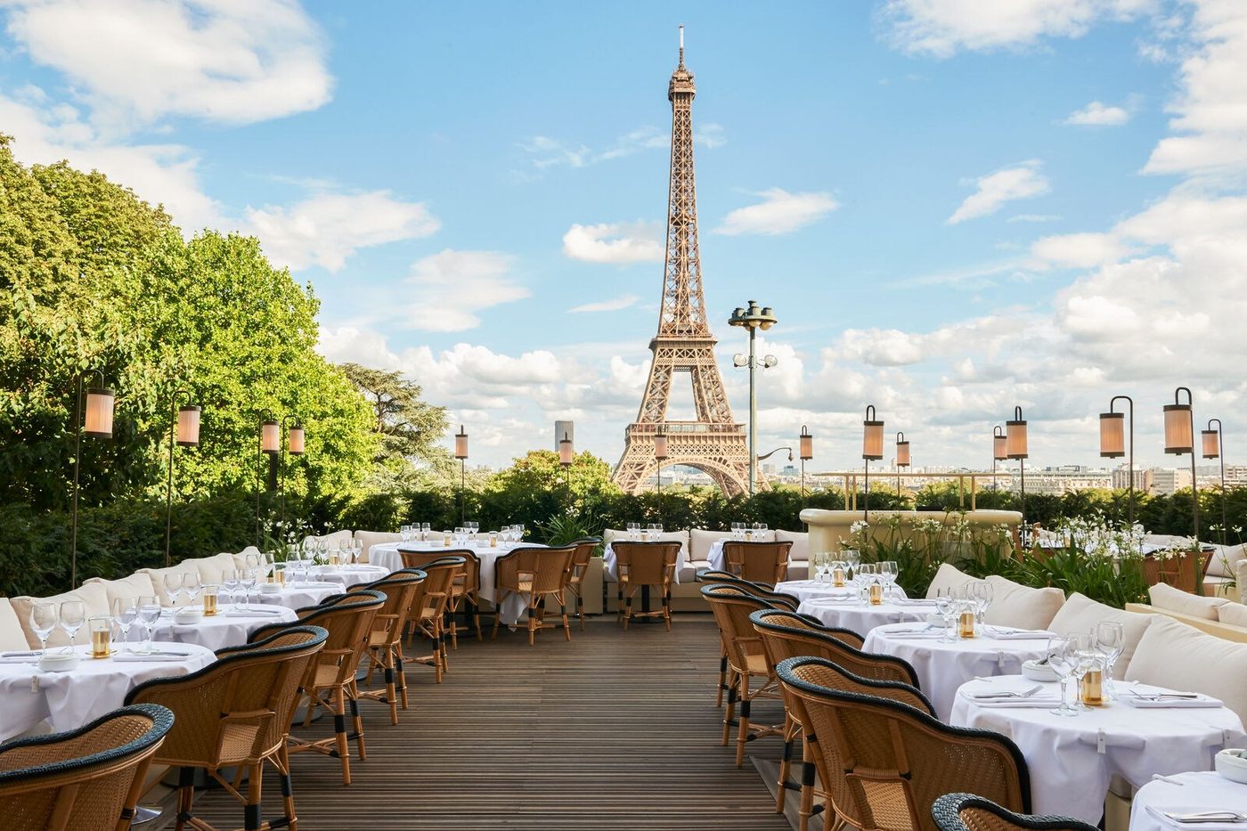 La terrasse de Girafe, allée de tables dressées et chaises en rotin, la tour Eiffel au centre