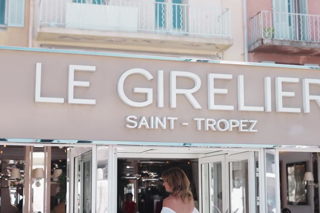 La façade du Girelier sur le port de Saint-Tropez, enseigne blanche et salle ouverte sur le quai
