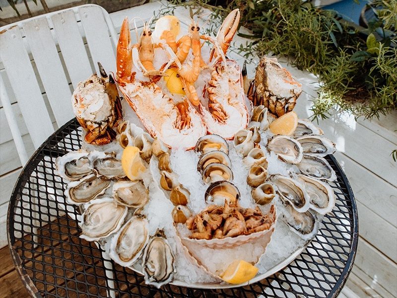 Un plateau de fruits de mer d'Huguette sur glace pilée : huîtres, crevettes roses et grises, bulots