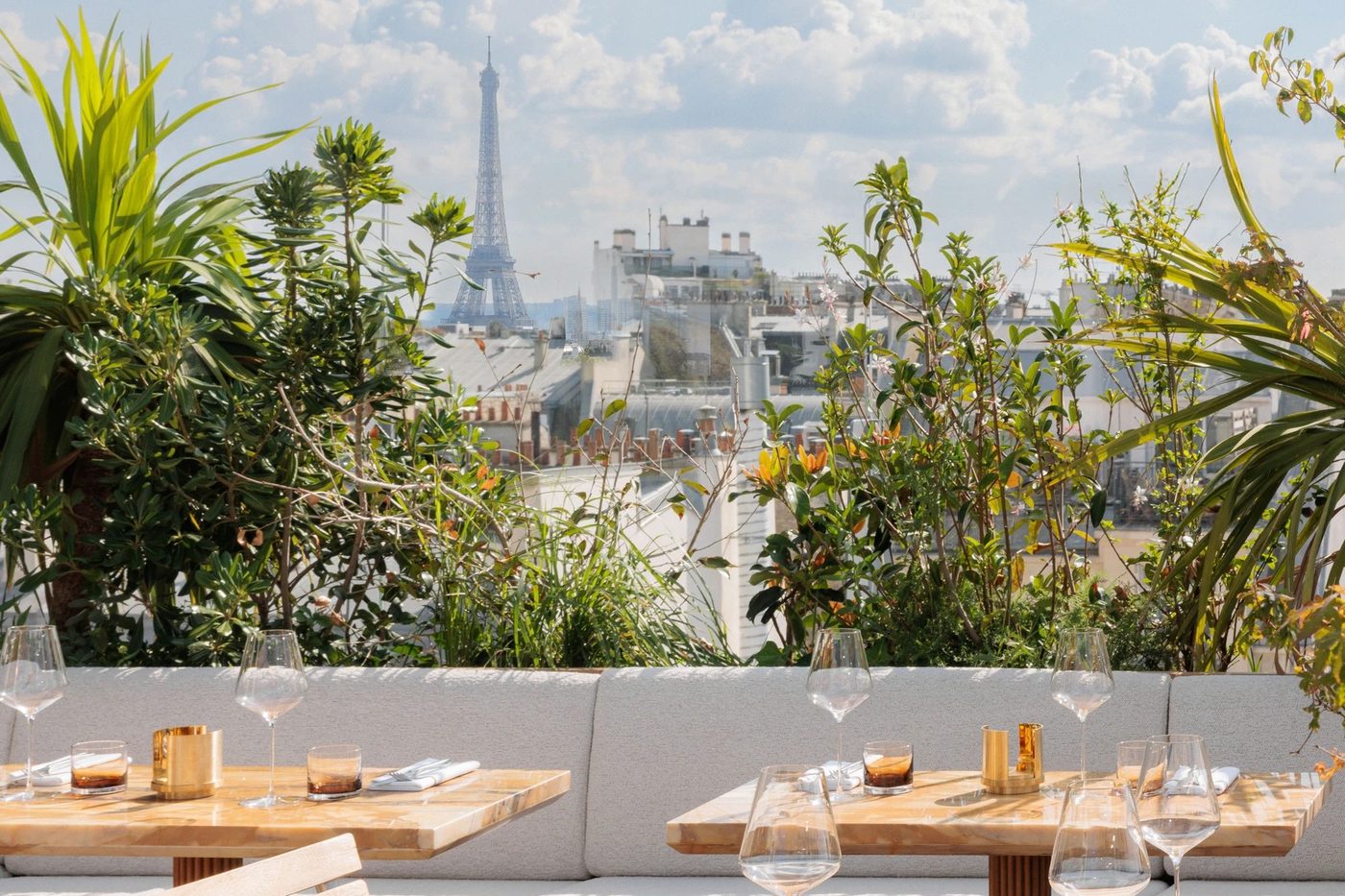 La terrasse végétalisée des Ailes, banquette et tables de bois dressées, la tour Eiffel au loin