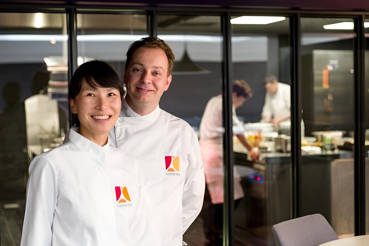 Mi-Ra Kim et Charles Thuillant en veste blanche devant la cuisine vitrée de L'Essentiel