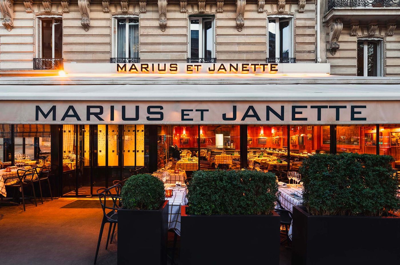 La devanture de Marius et Janette, avenue George-V, sa terrasse éclairée et ses haies de buis