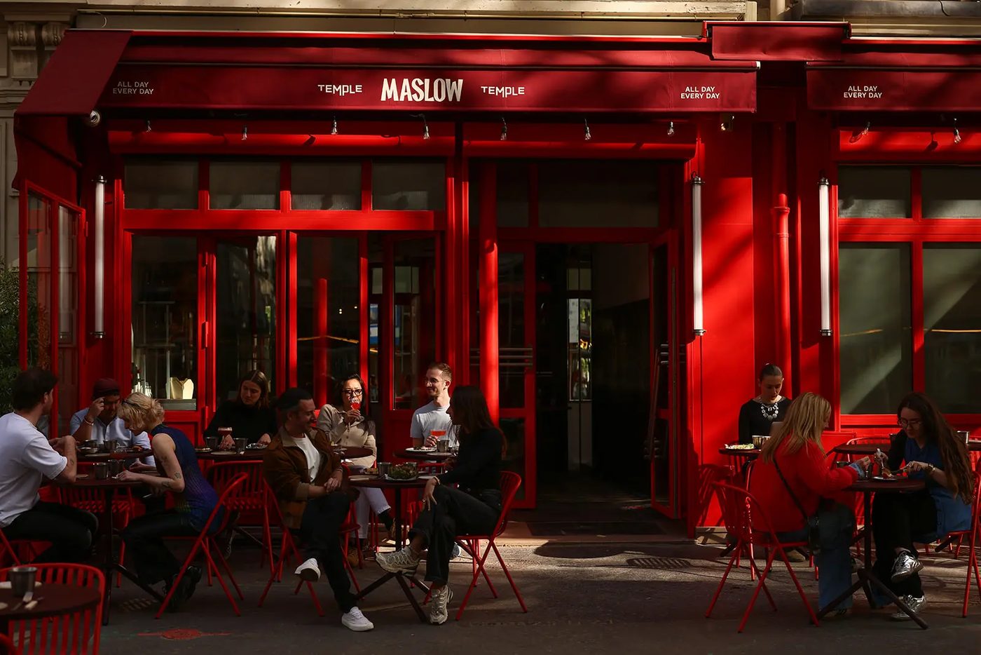 La devanture rouge de Maslow Temple, rue de Picardie, et sa terrasse aux chaises rouges pleine de convives
