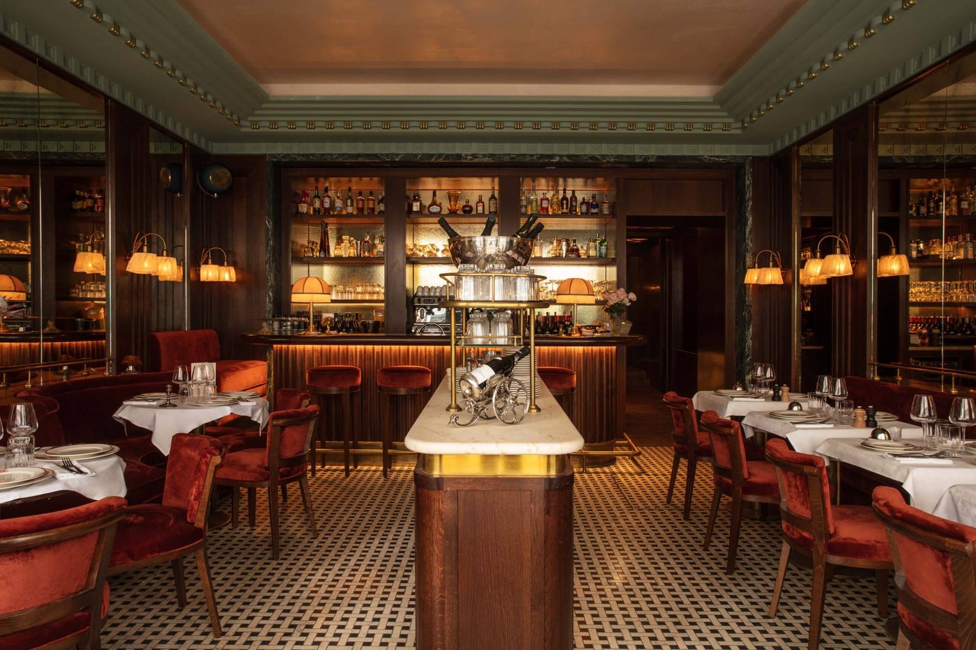 La salle de Maison François 1er vers le bar, desserte de bois et marbre, banquettes de velours rouge et sol en mosaïque