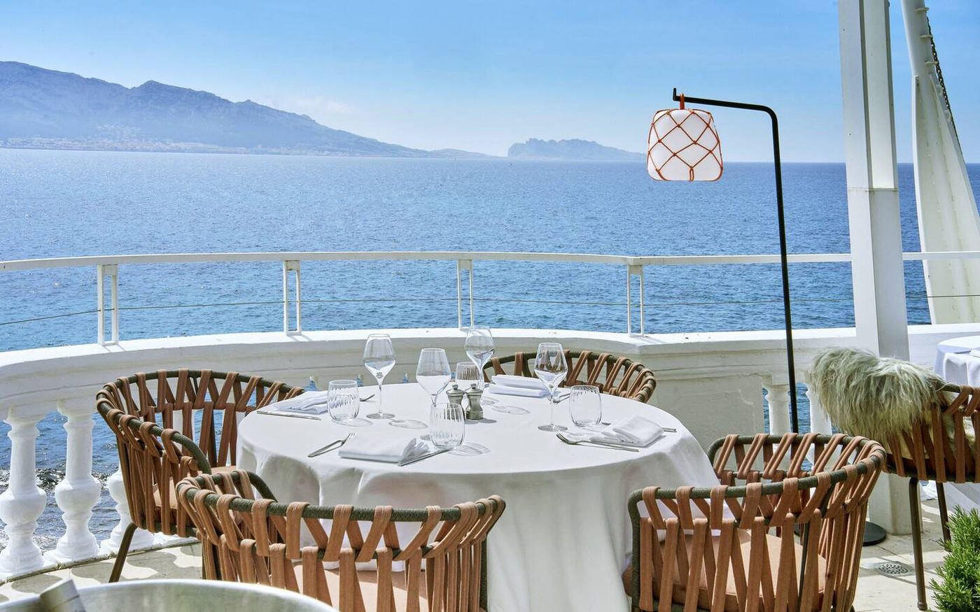 Une table dressée sur la terrasse blanche du Petit Nice, face à la mer et aux îles au loin