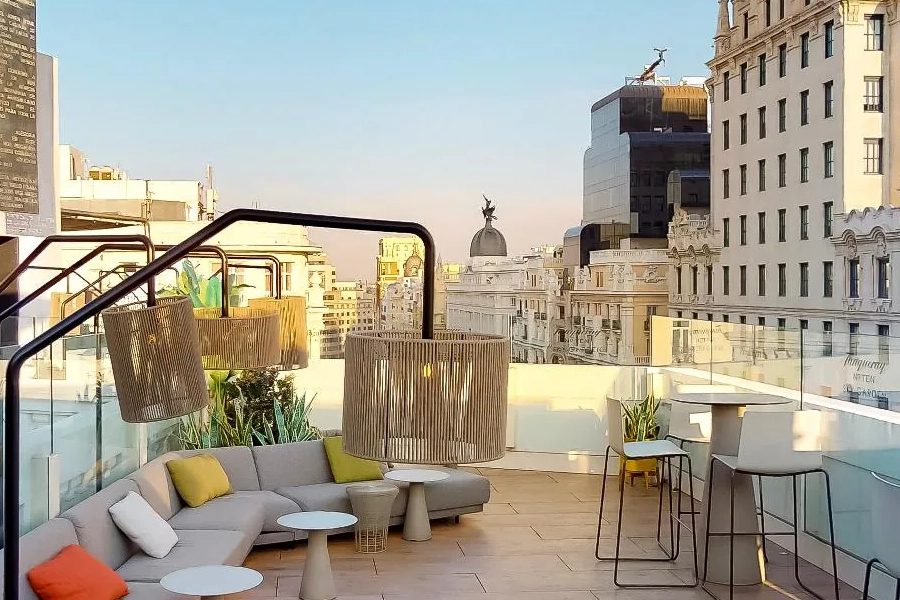 La terrasse du Picalagartos Sky Bar, canapés et luminaires suspendus, avec la Gran Vía et ses coupoles en contrebas