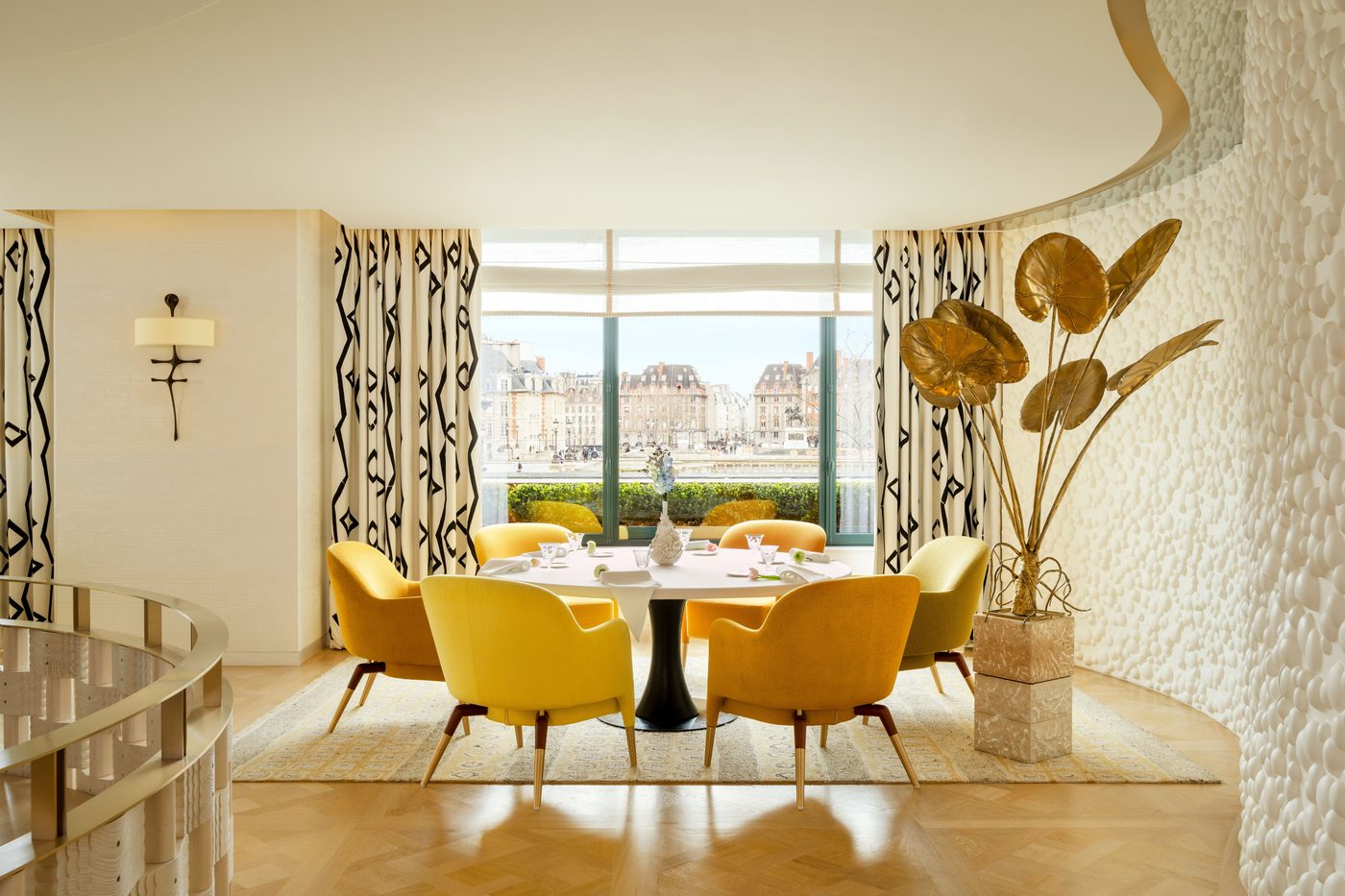 La salle de Plénitude, fauteuils jaunes, lampes dorées en forme de feuilles et grandes fenêtres ouvertes sur les toits de la rive gauche