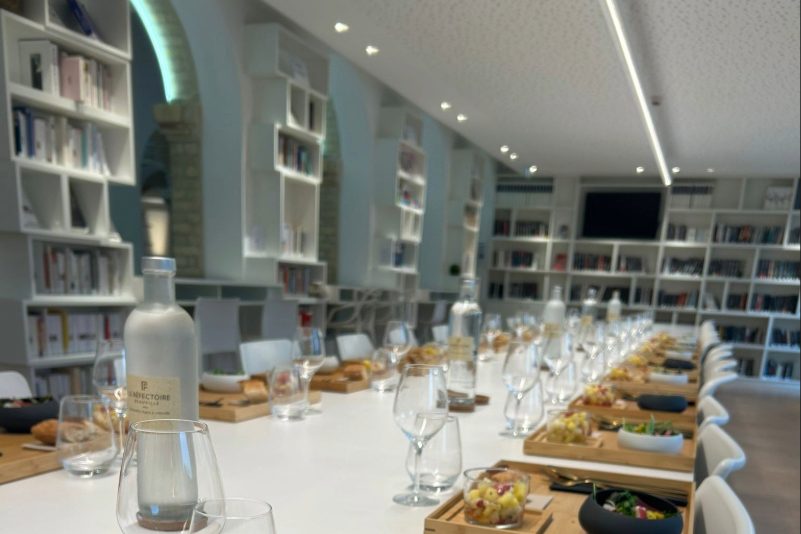 La longue table du Réfectoire dressée sous une voûte, entre les rayonnages de livres des Franciscaines
