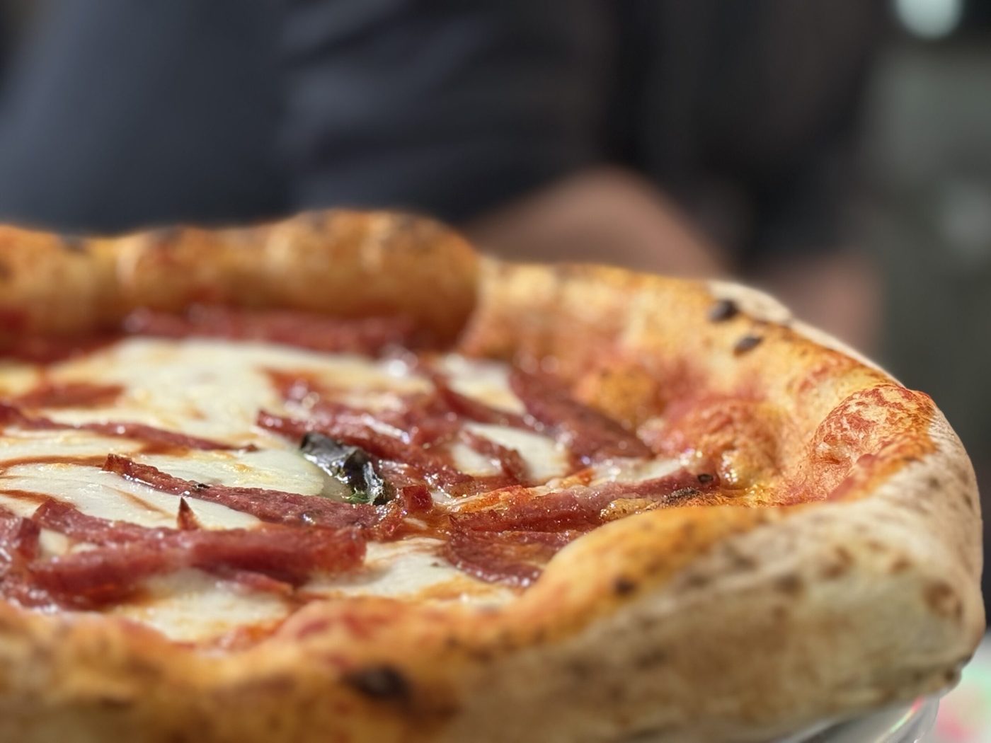 Une pizza napolitaine de La Reginella vue de près, le bord gonflé et tacheté par la cuisson