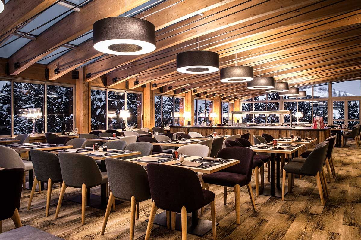 La grande salle des Terrasses du Rif Briant, tables de bois sous des suspensions noires, baies vitrées