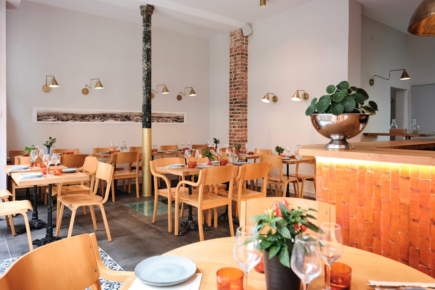La salle de Sama, ses tables en bois blond et son comptoir carrelé d'orange