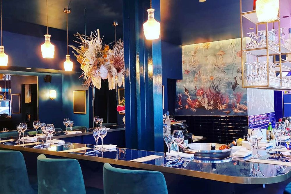 La salle du Seafood, rue de Turenne : bar, fauteuils de velours bleu et fresque marine au mur