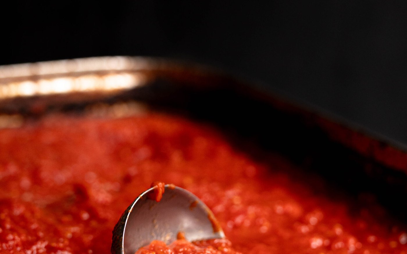 Une sauce tomate en cuisson dans une grande casserole chez Sugo, à Paris