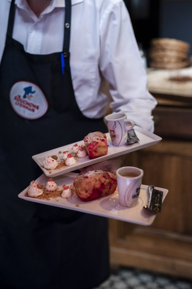 Un serveur du Bouchon Sully portant deux desserts