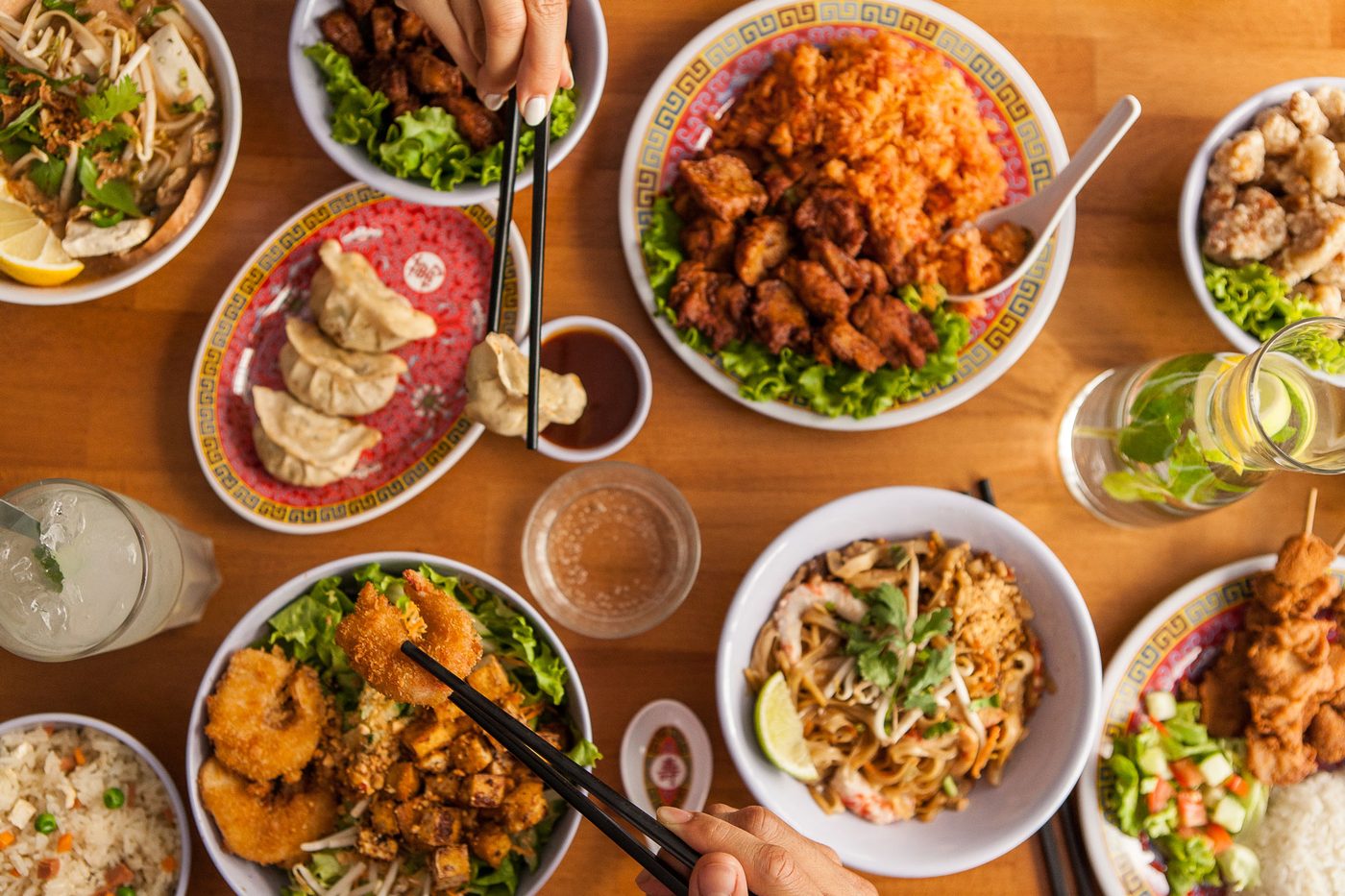 Une table de Tien Hiang couverte de plats asiatiques végétariens, nouilles sautées, bouchées vapeur et salades
