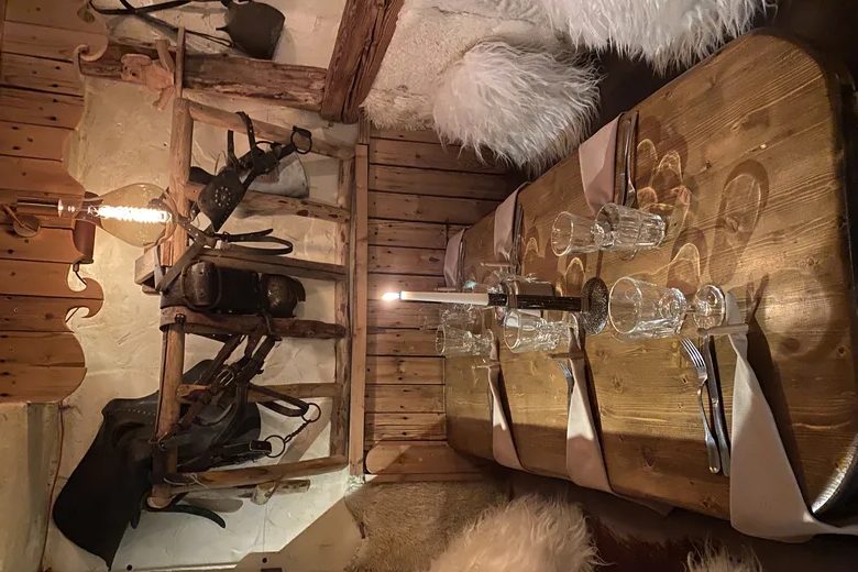 Une table du Torrent dressée de verres, dans un décor de bois et de peaux de bête