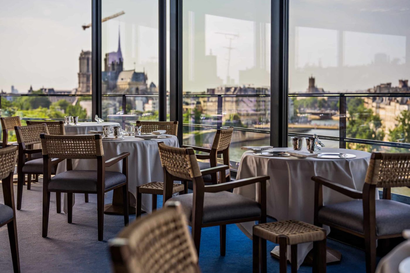 La salle de La Tour d'Argent, tables nappées devant les baies ouvertes sur la Seine et Notre-Dame
